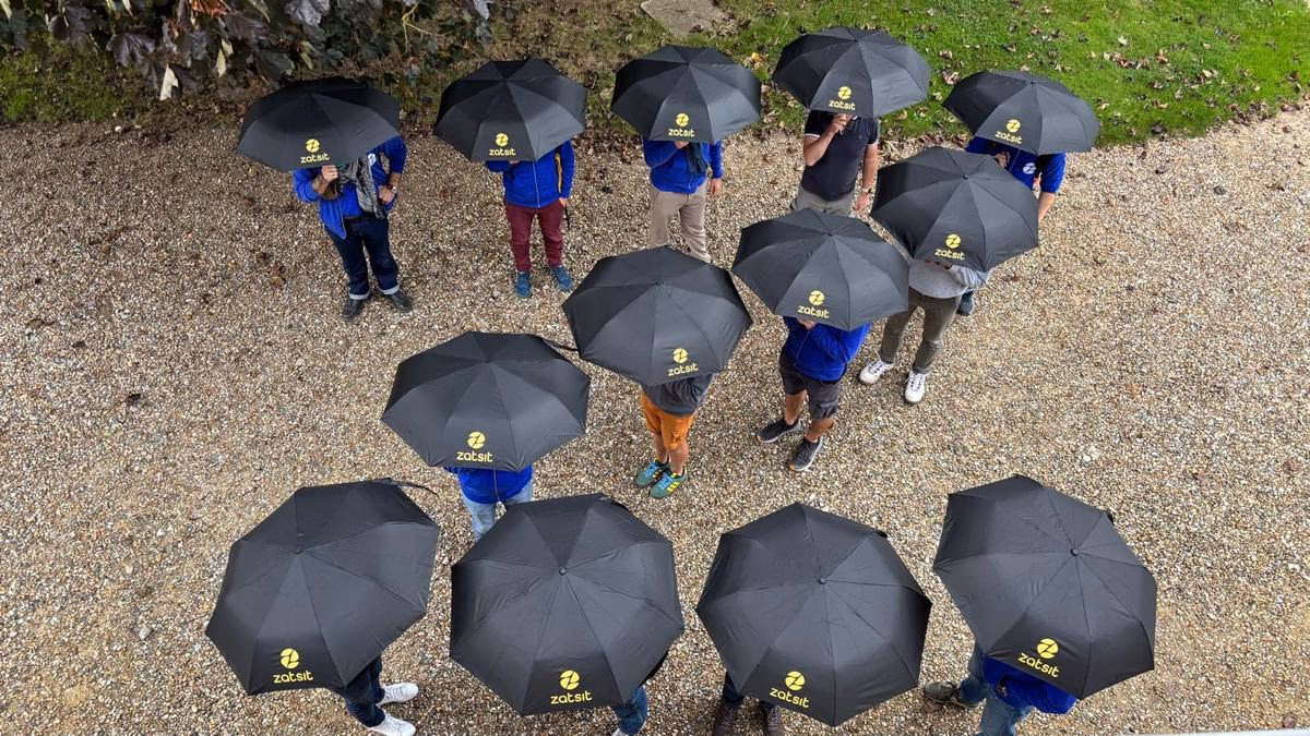 Vue d'en haut : une quinzaine de parapluies noirs siglés zatsit